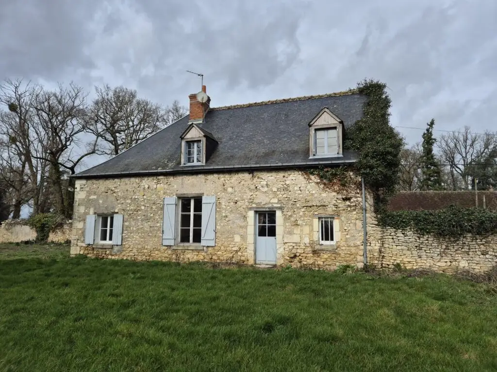 Maison en pierre avec volets bleus et toit ardoise